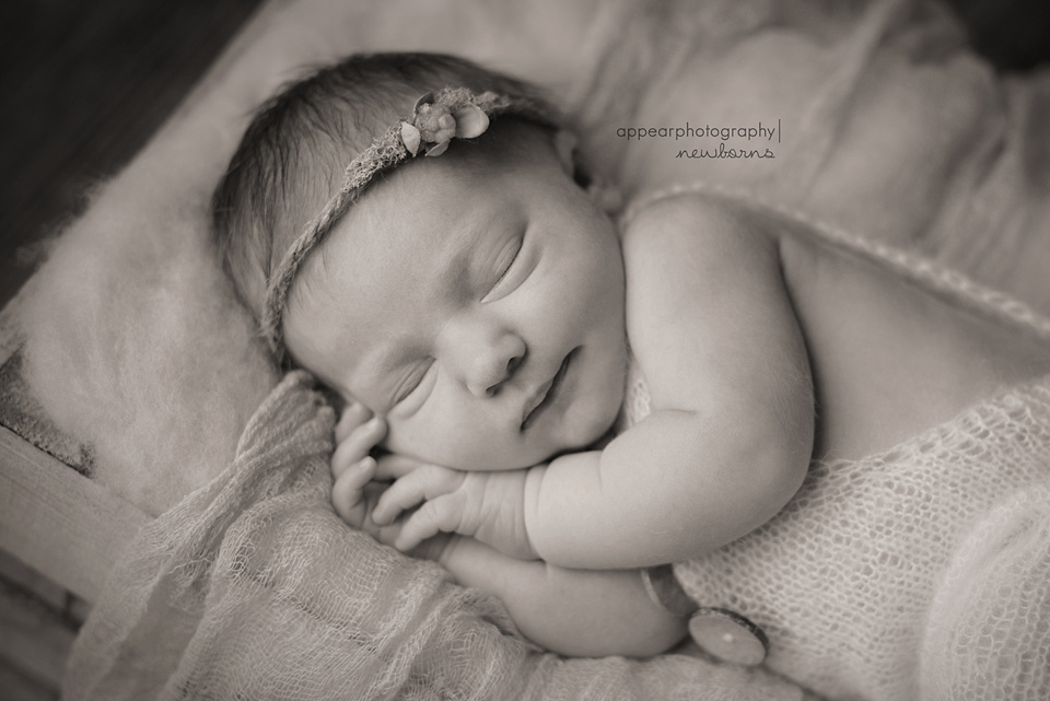 Appear Photography, Hoover, Birmingham, AL newborn baby photographer, newborn baby smiling, hands under face, black and white, mohair rompers